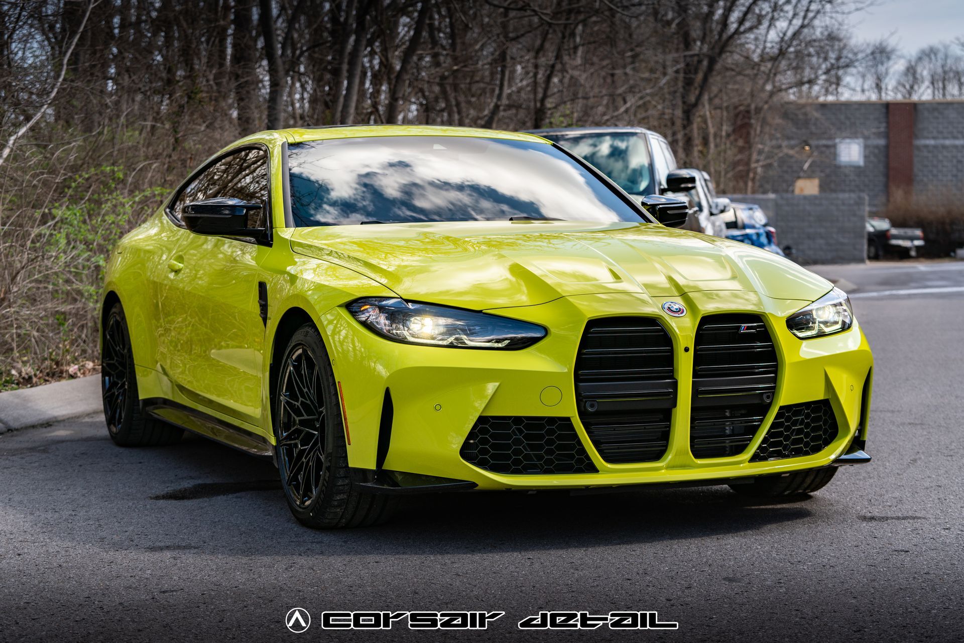 A yellow bmw m4 is parked in a parking lot.