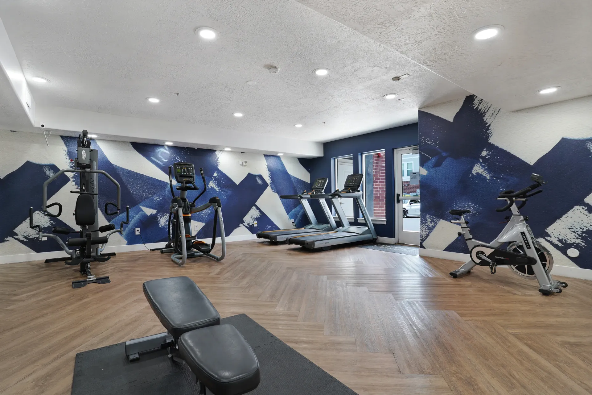 Fitness center with treadmills, elliptical, stationary bike, and weight machine at Hills at Renaissance, offering apartments in Bountiful, UT.