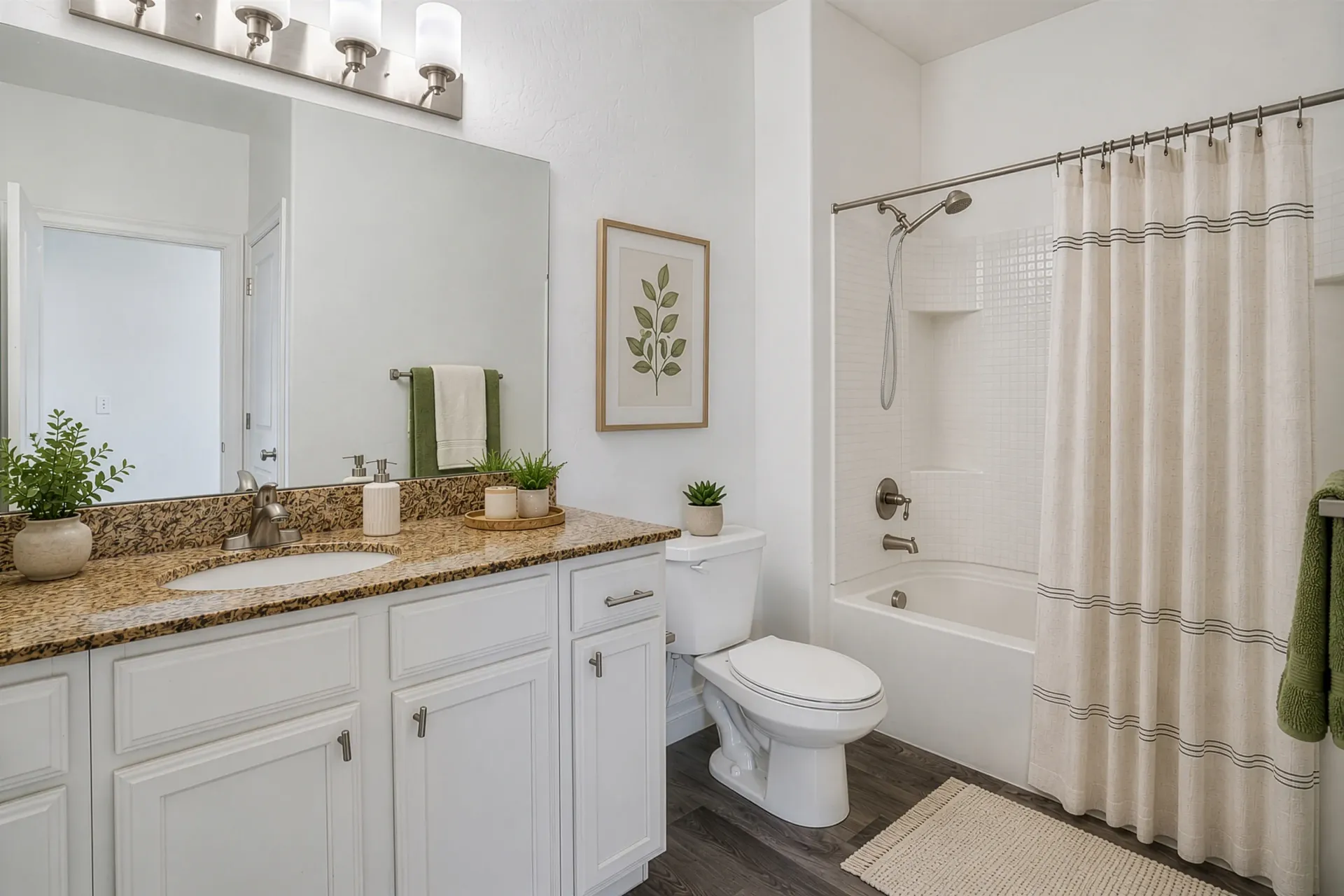 Bathroom with vanity, toilet, and bathtub with shower curtain at Hills at Renaissance, offering apartments for rent in Bountiful, UT.