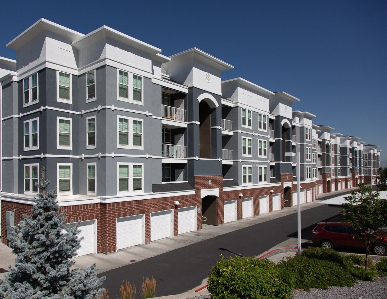 Hills at Renaissance apartment building with row of garages.