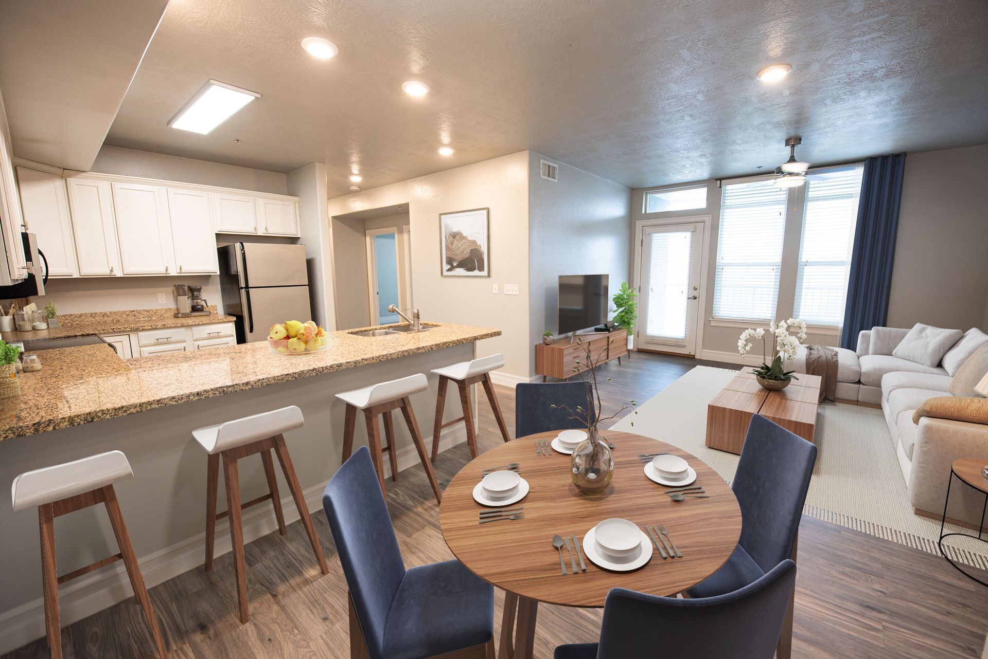Hills at Renaissance  kitchen and living area with a breakfast bar, dining table, and light-colored furniture.