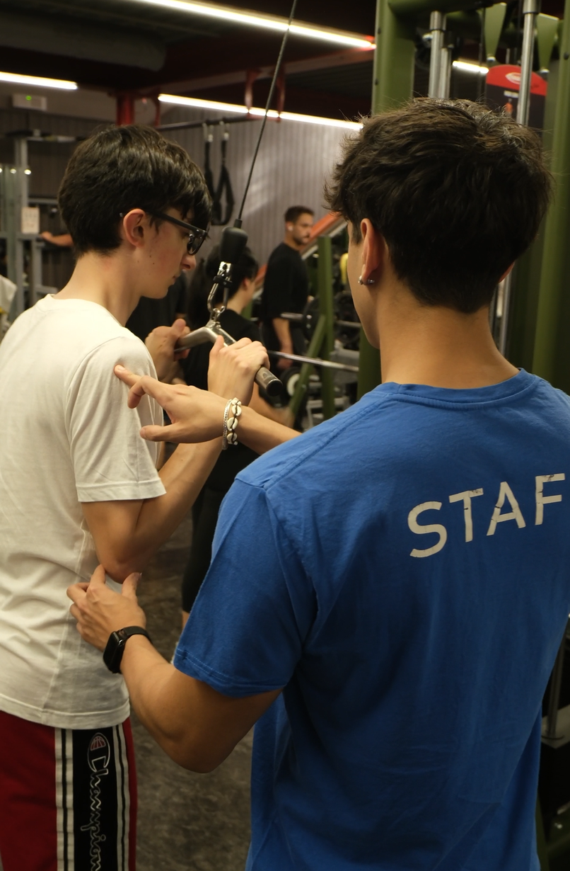 Personal Trainer assiste un cliente in sala pesi
