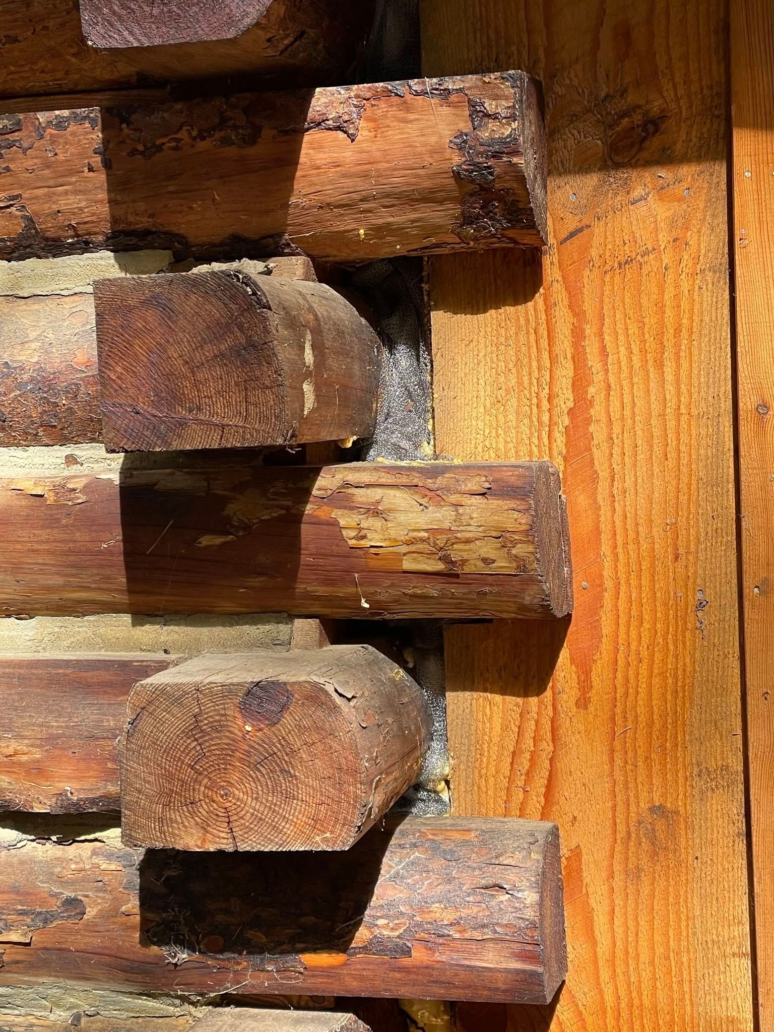 A close up of a wooden wall with logs stacked on top of each other.