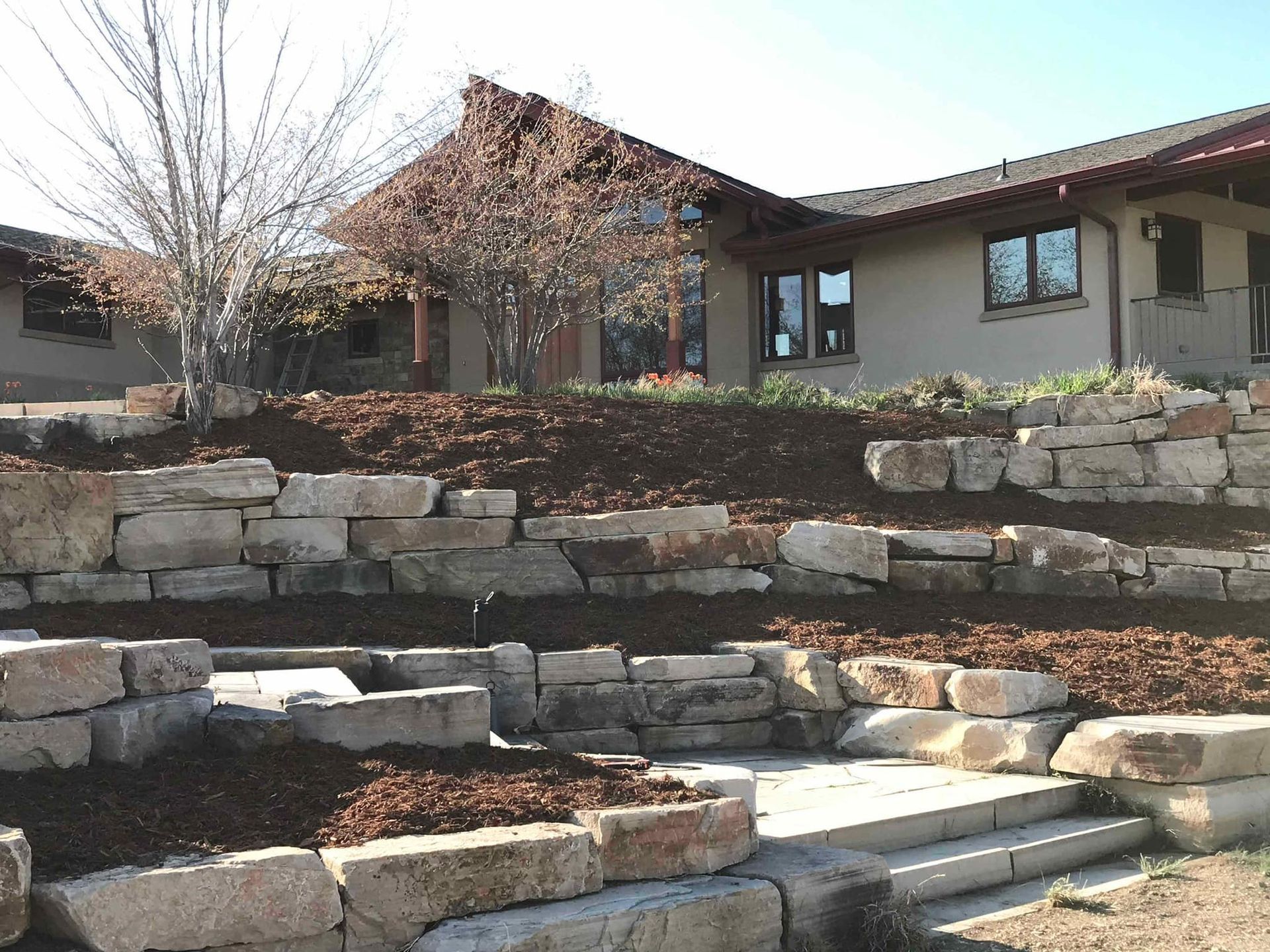 A house with a stone wall in front of it