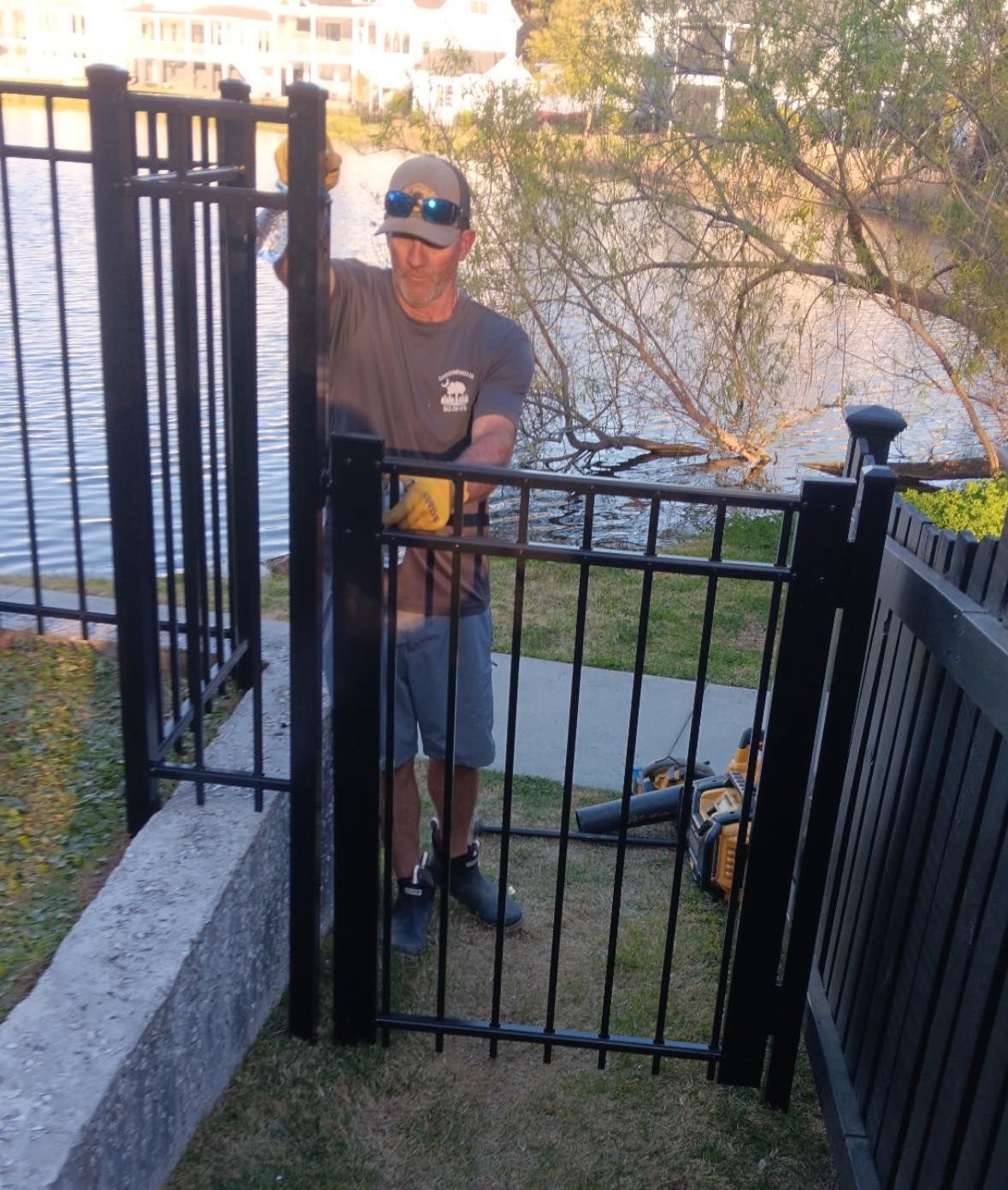 A man is standing in front of a black gate