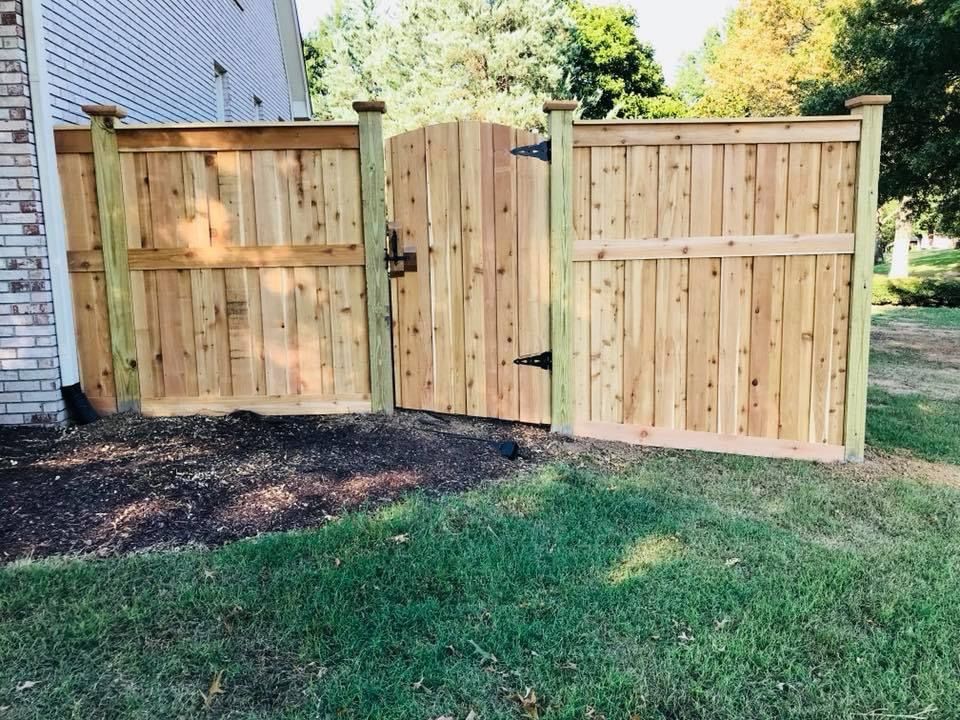 A wooden fence with a gate in the backyard of a house.