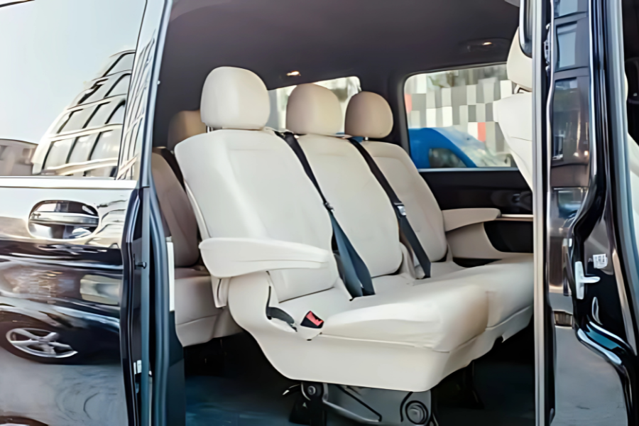 Interior view of Athenaos Travel & Tours Mercedes minivan with beige leather seats for comfortable private transfers.