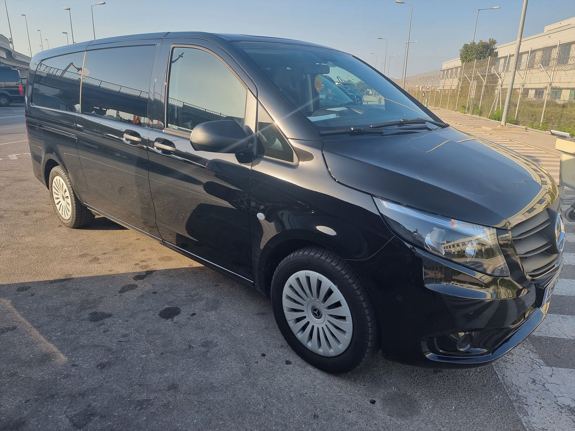 Athenaos Travel & Tours premium Mercedes van at Athens Airport parking area ready for transfer service.
