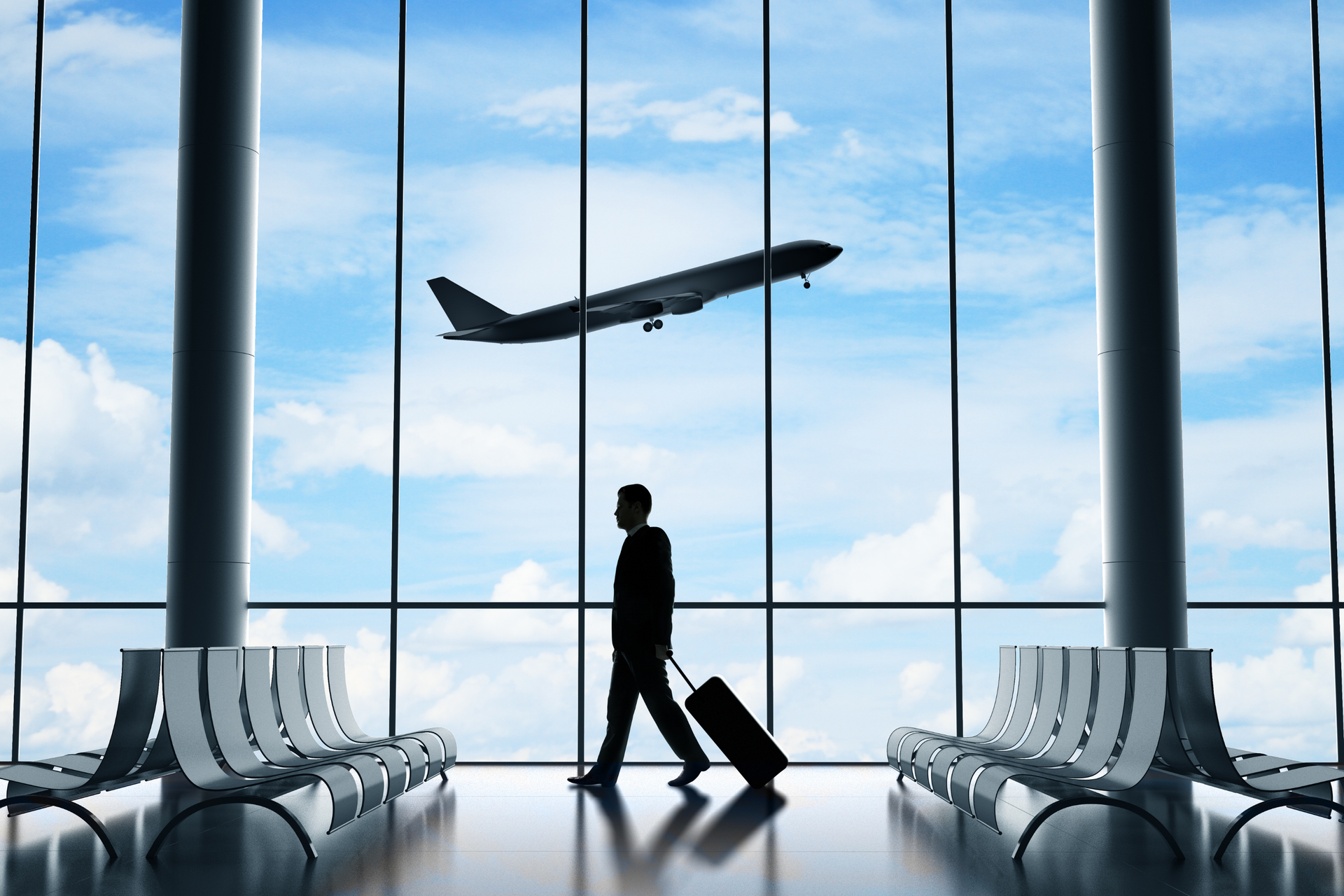 Un viajero con su equipaje observa el despegue de un avión en la terminal del aeropuerto, que representa las conexiones aéreas de Atenas con Athenaos.