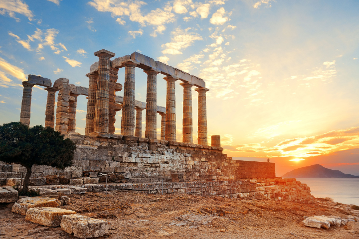 The Temple of Poseidon at Cape Sounion during sunset overlooking the Aegean Sea.