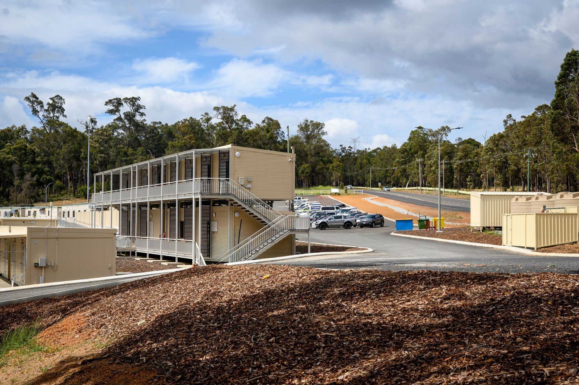 Modern two-story modular accommodation buildings at Collie Hills Village with surrounding landscape.