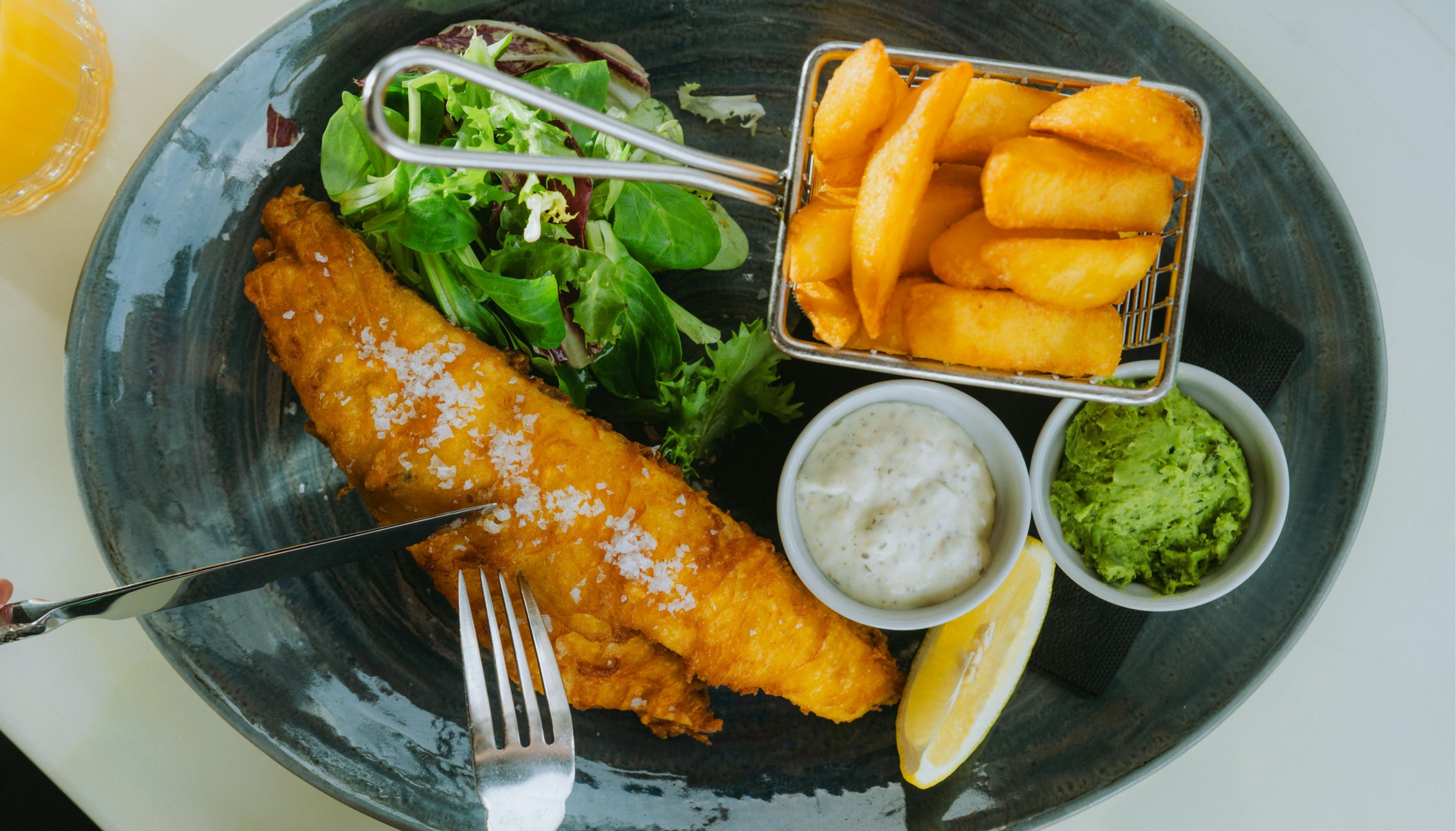Fish and chips with salad and dipping sauces served on a plate