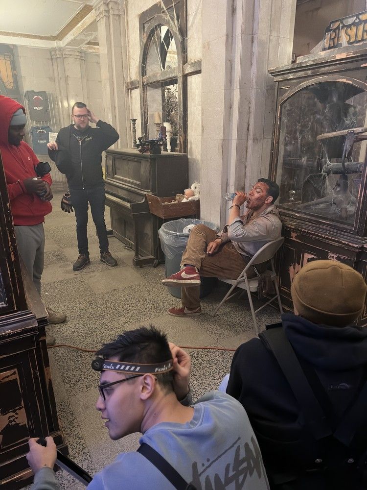 A group of men are standing and sitting in a room.