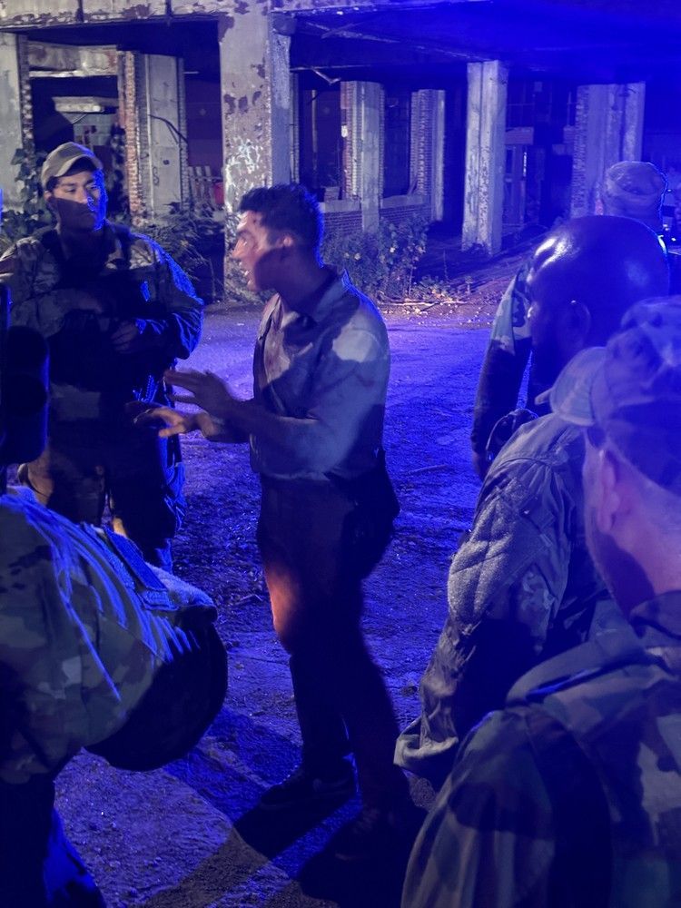 A group of soldiers are standing next to each other in front of a building.