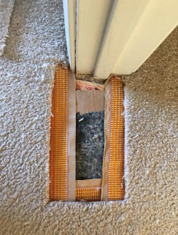A man is measuring a piece of carpet with a tape measure.