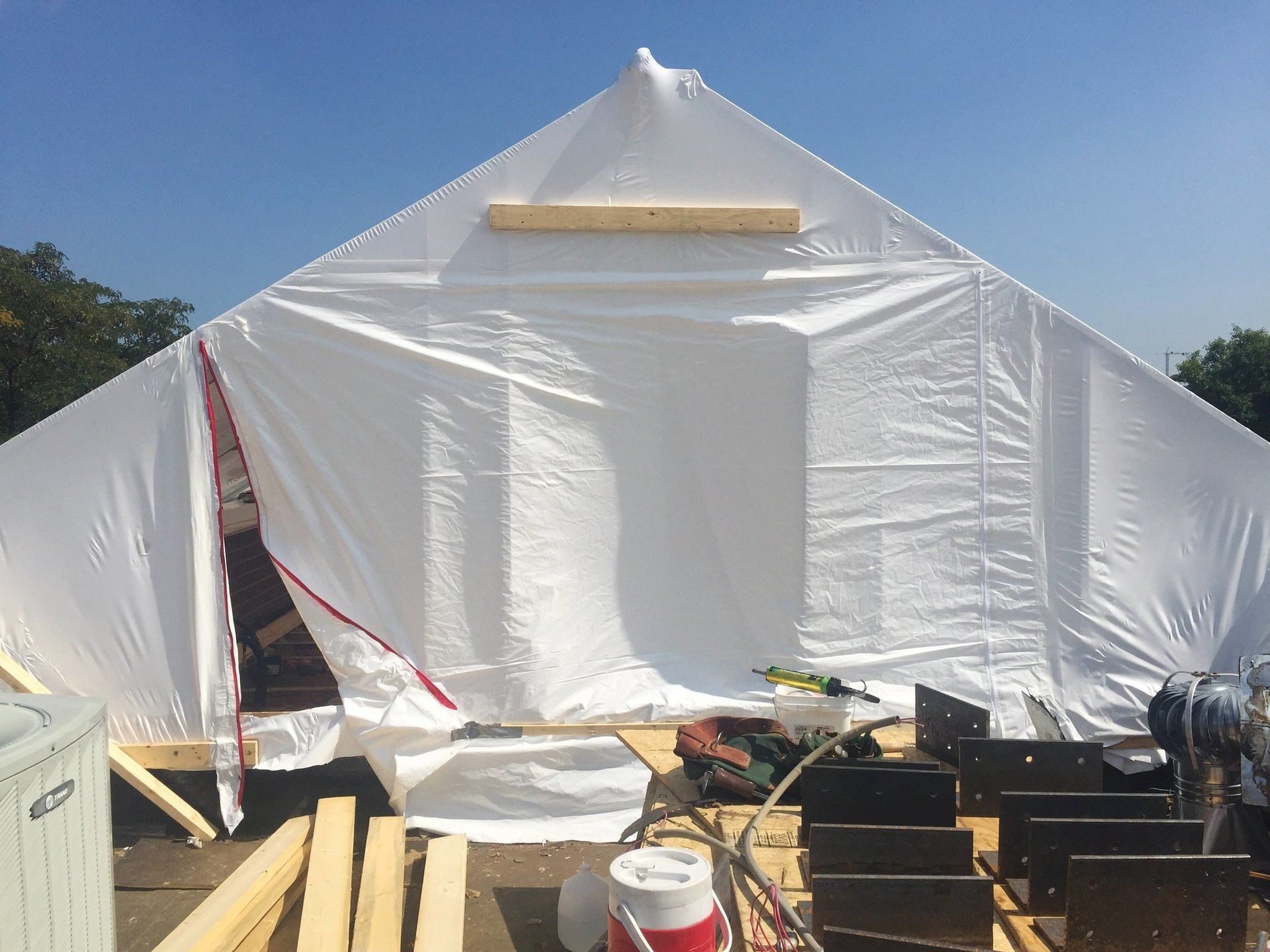 Fully set up construction tent on top of a roof