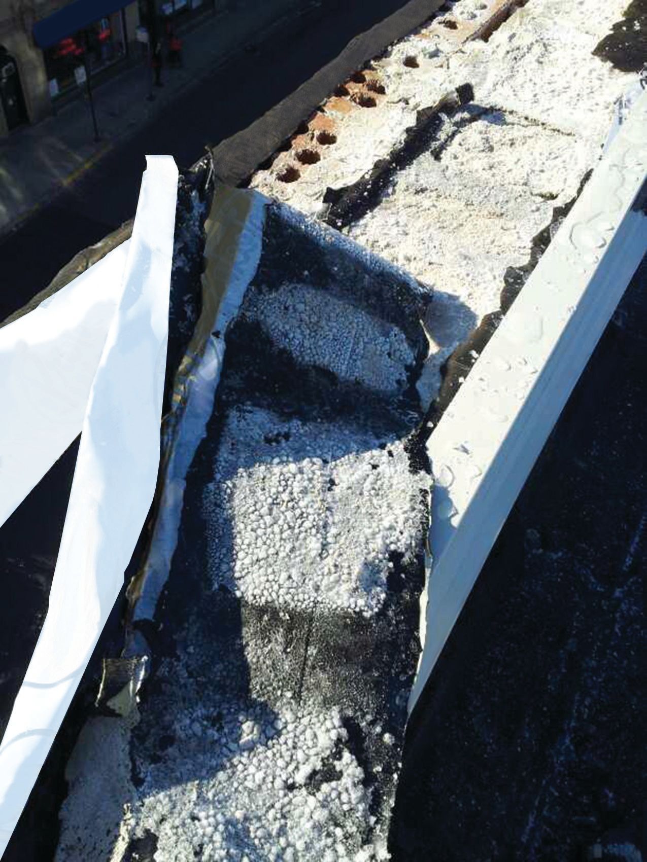 Frost under self-adhered flashing on brick-block parapet wall Lakeview, Chicago.