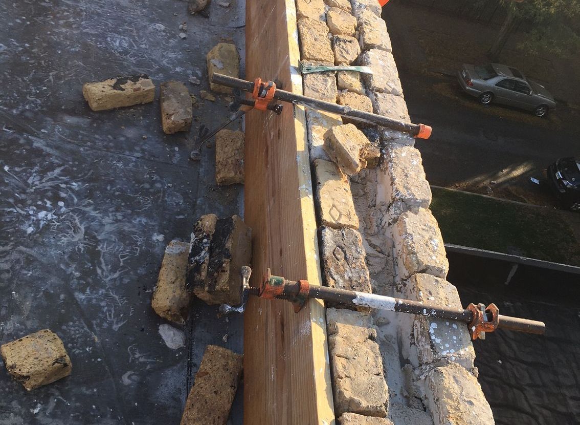 Historic common brick wall held together with threaded rods preparing for lime mortar infusion