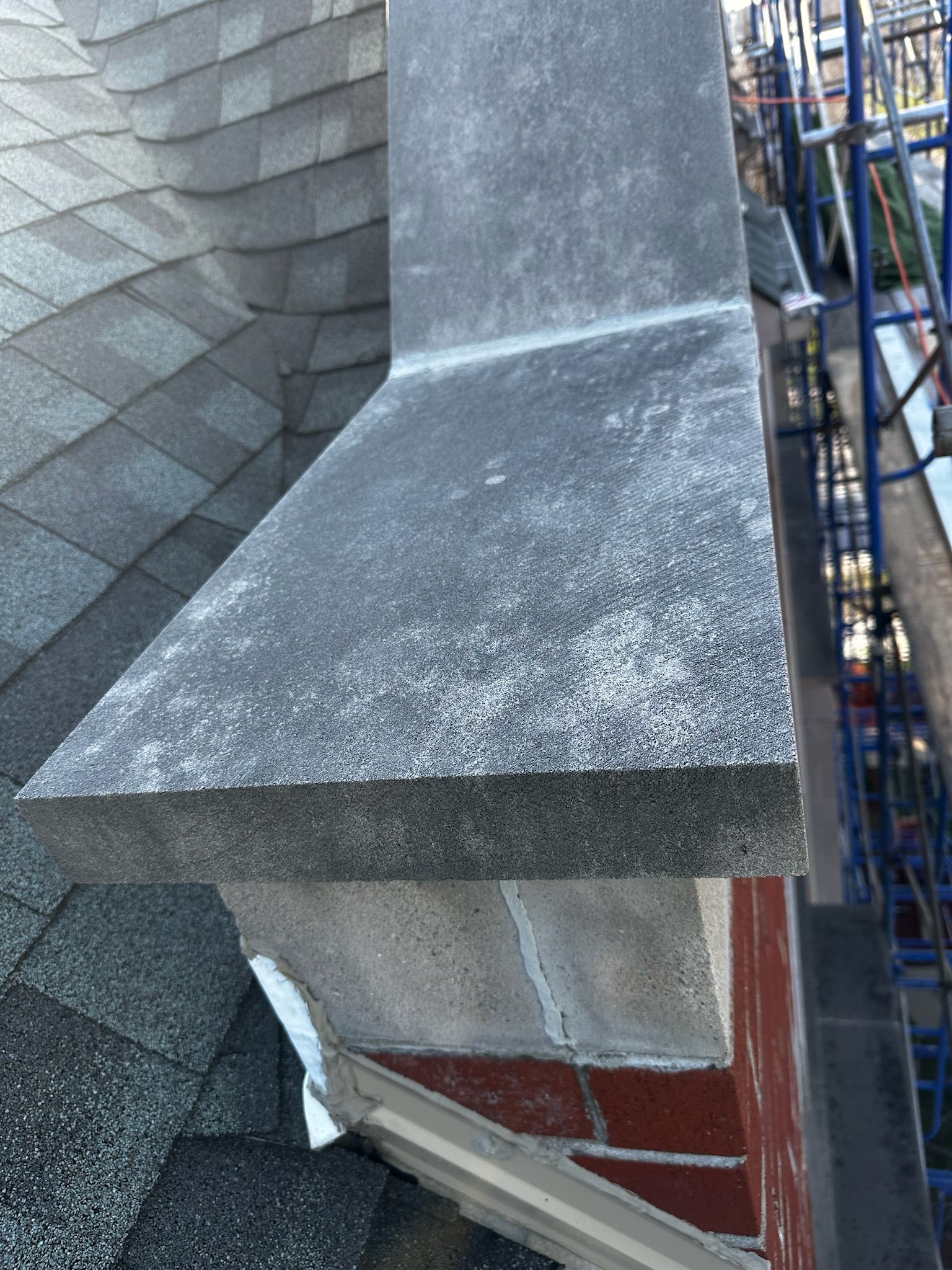 Close-up of leaking damaged capstone on top of parapet wall