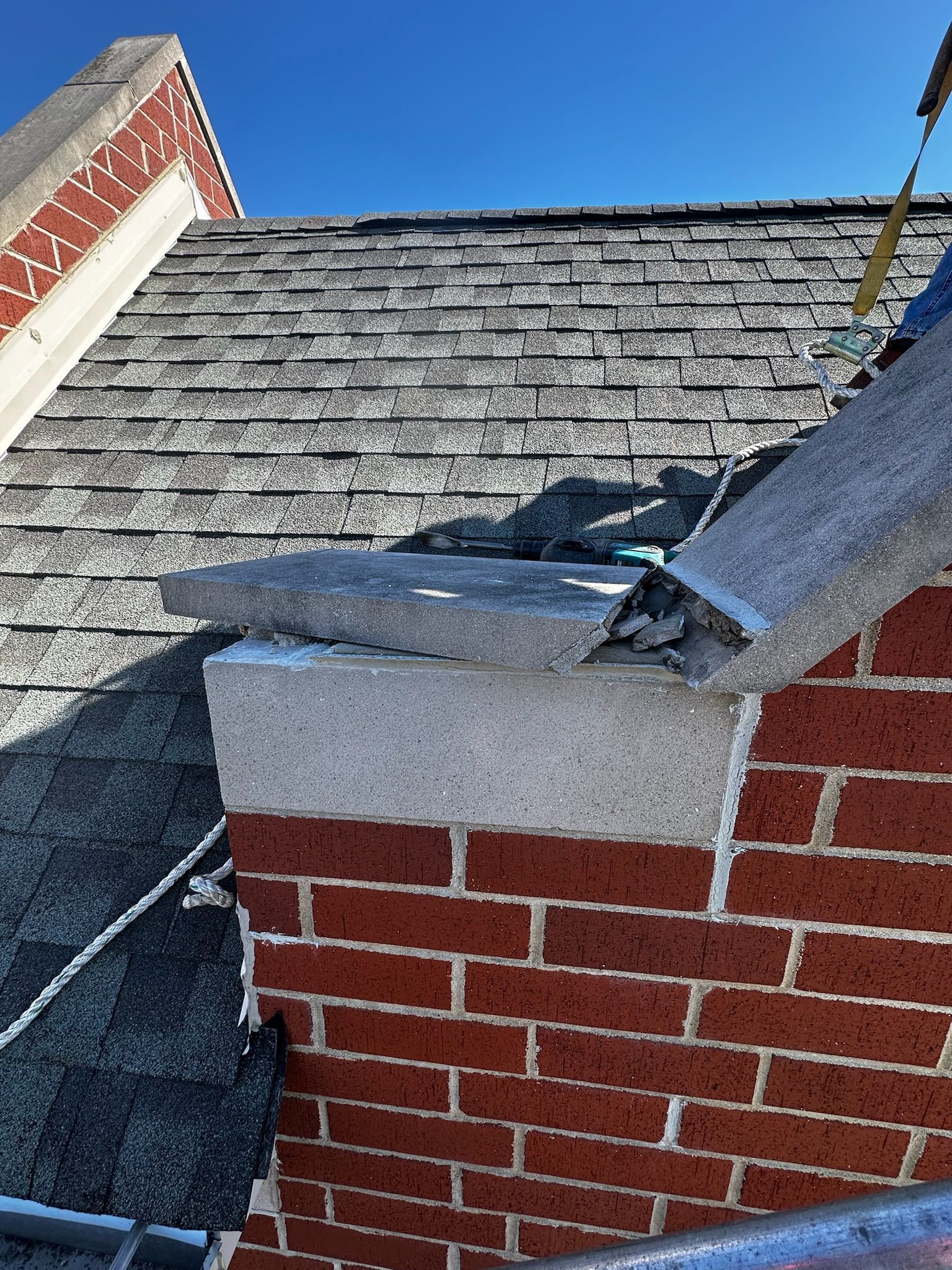 Cracked capstone on top of shingled rooftop
