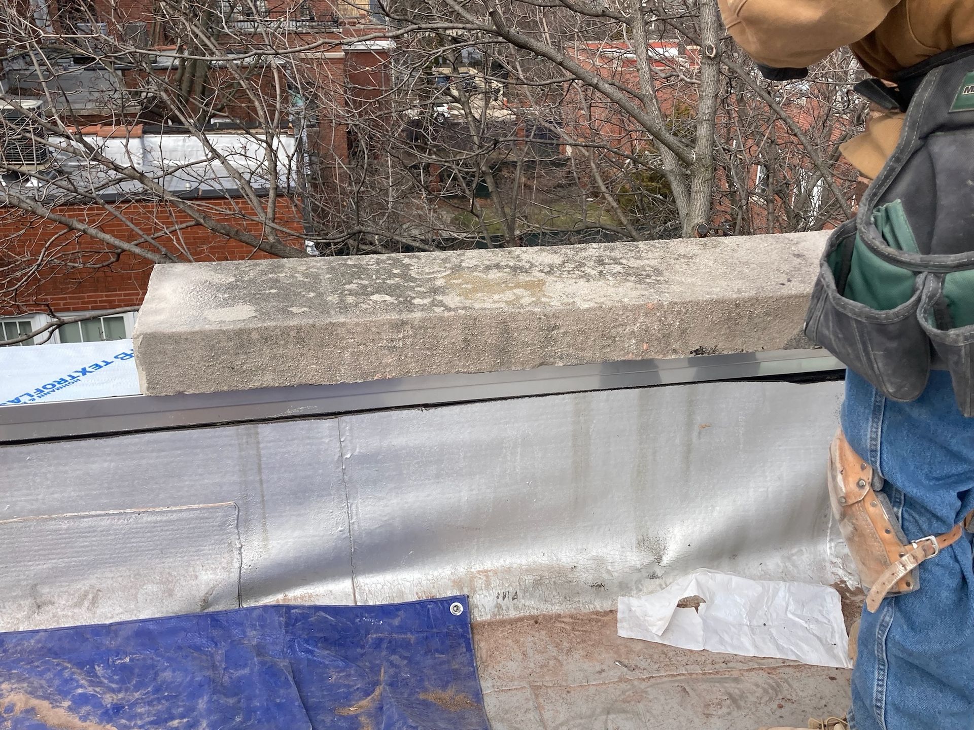 Capstone on top of newly installed flashing on parapet wall