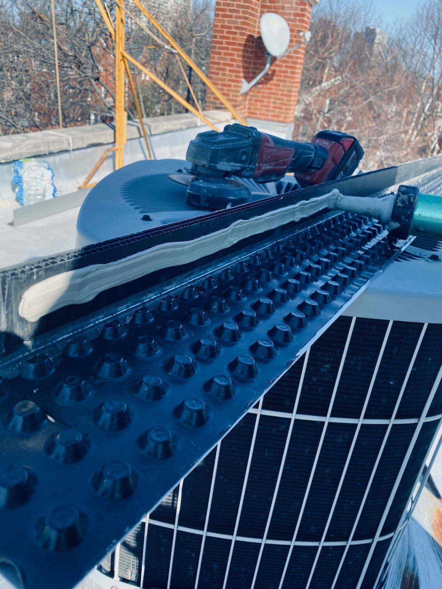Parapet vent with sealant on resting on AC unit 