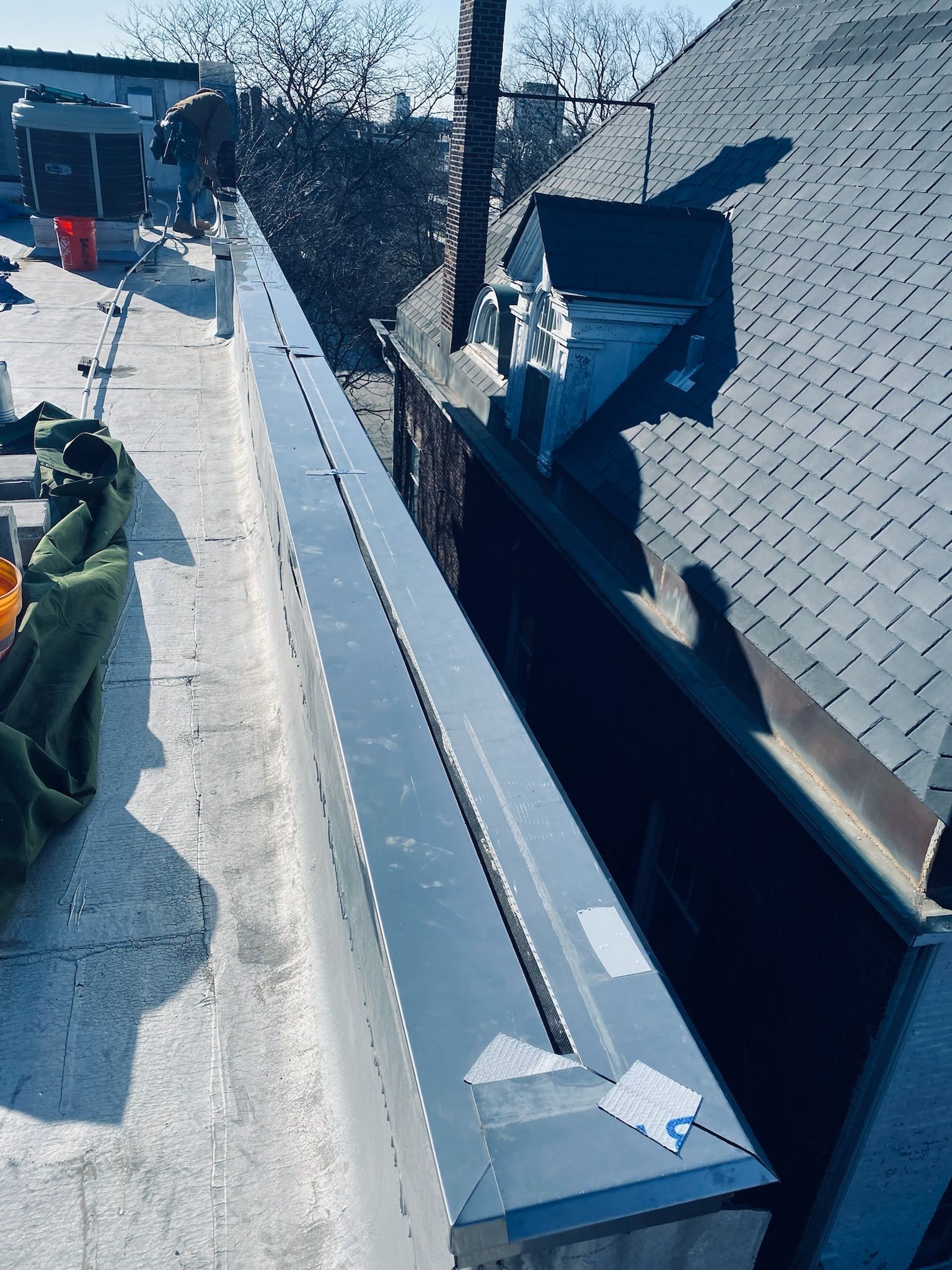 Rooftop construction with metal flashing along parapet wall