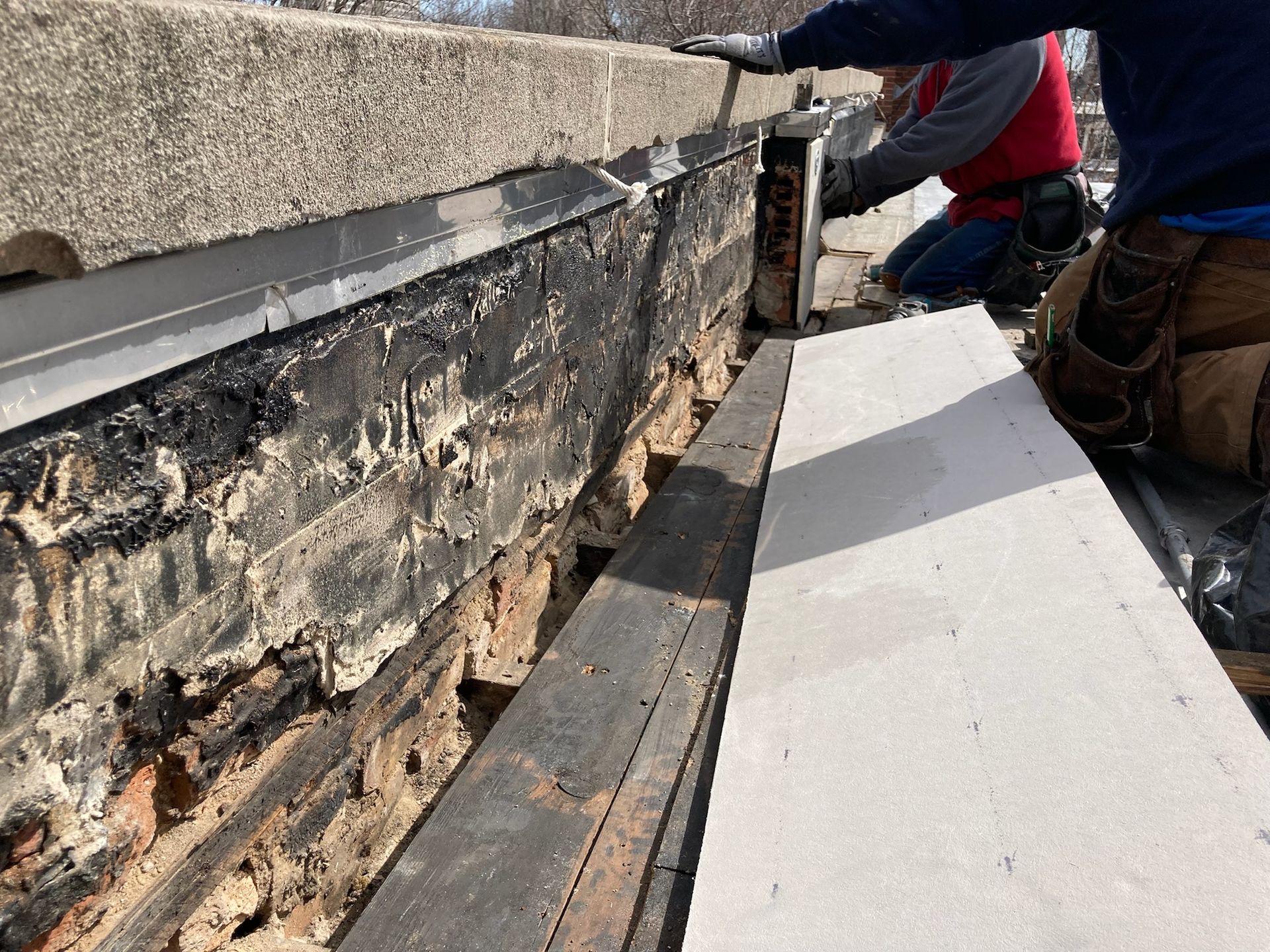 Workers placing capstone on top of venting system