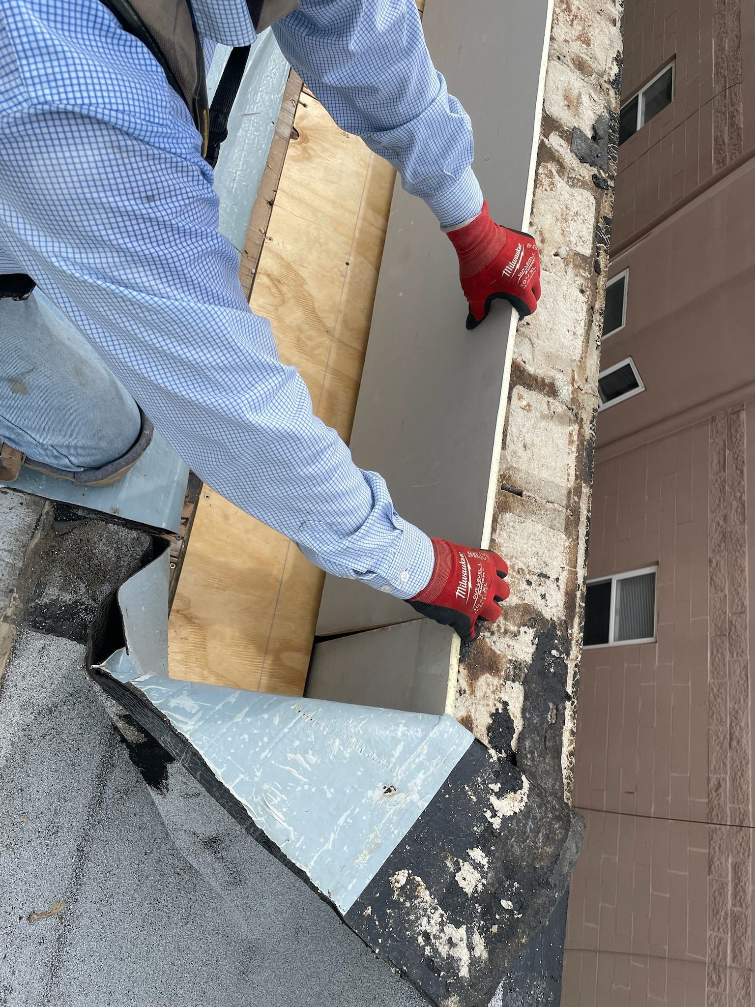 Worker installing insulation on a building exterior wall