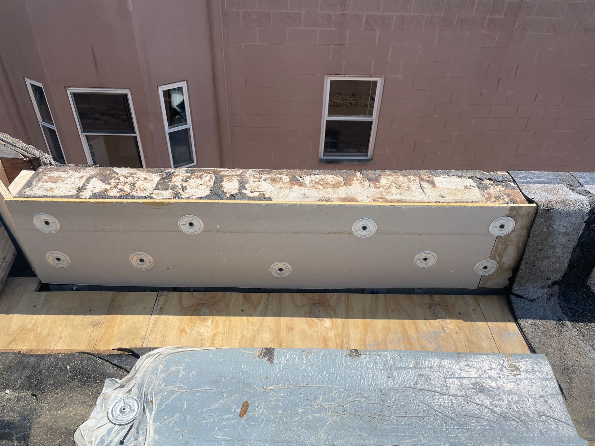 Parapet wall with insulation installed against it