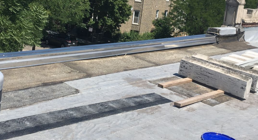 Flat rooftop with roofing materials and wooden planks