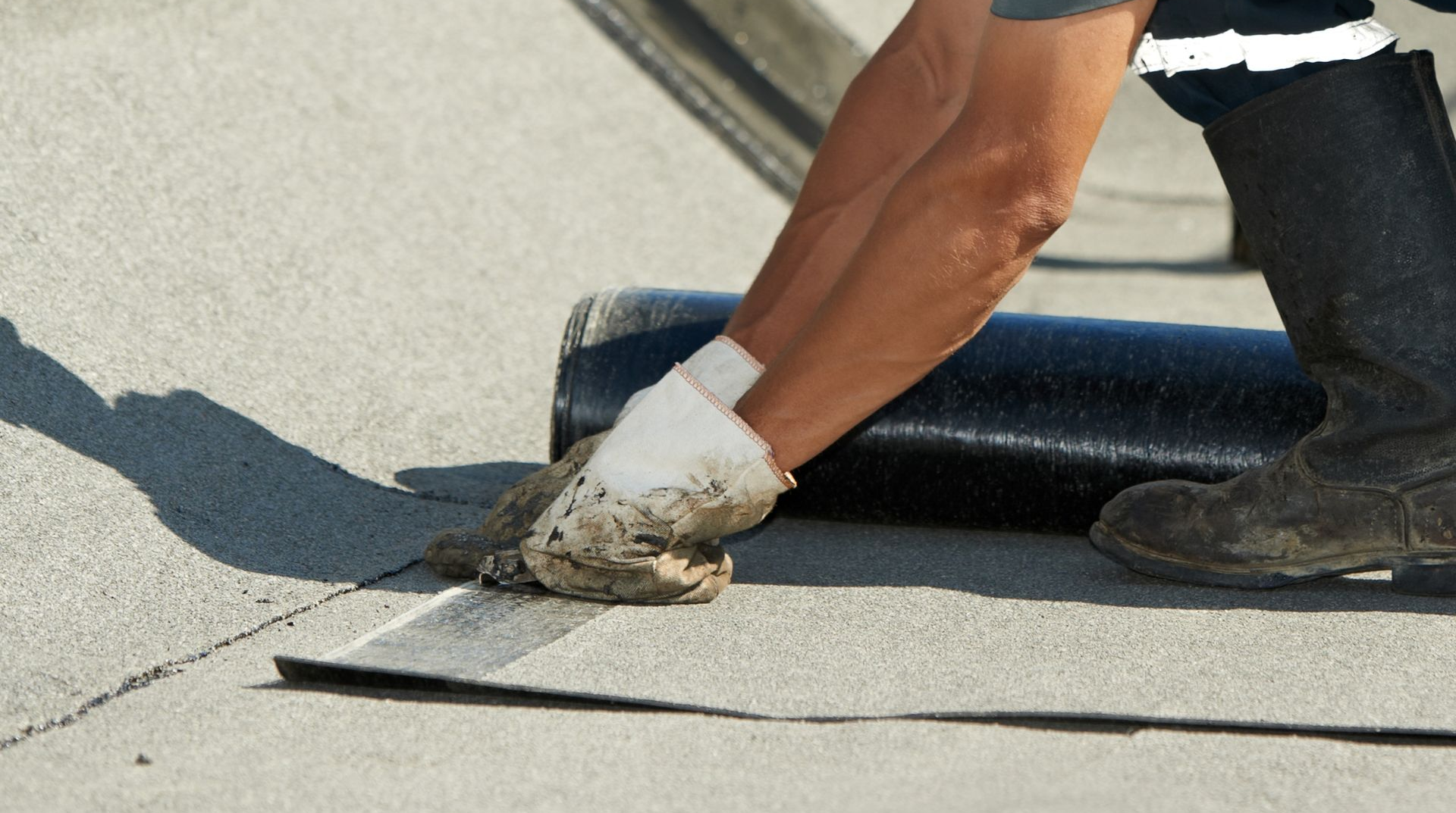 Worker troweling material on a flat roof