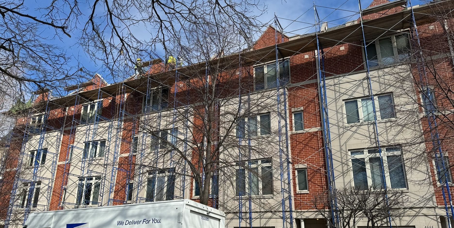 Row of brick apartment buildings with scaffolding set up all across the buildings