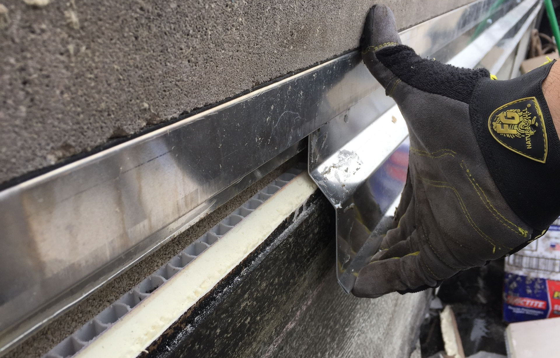 Worker installing flashing on a parapet wall