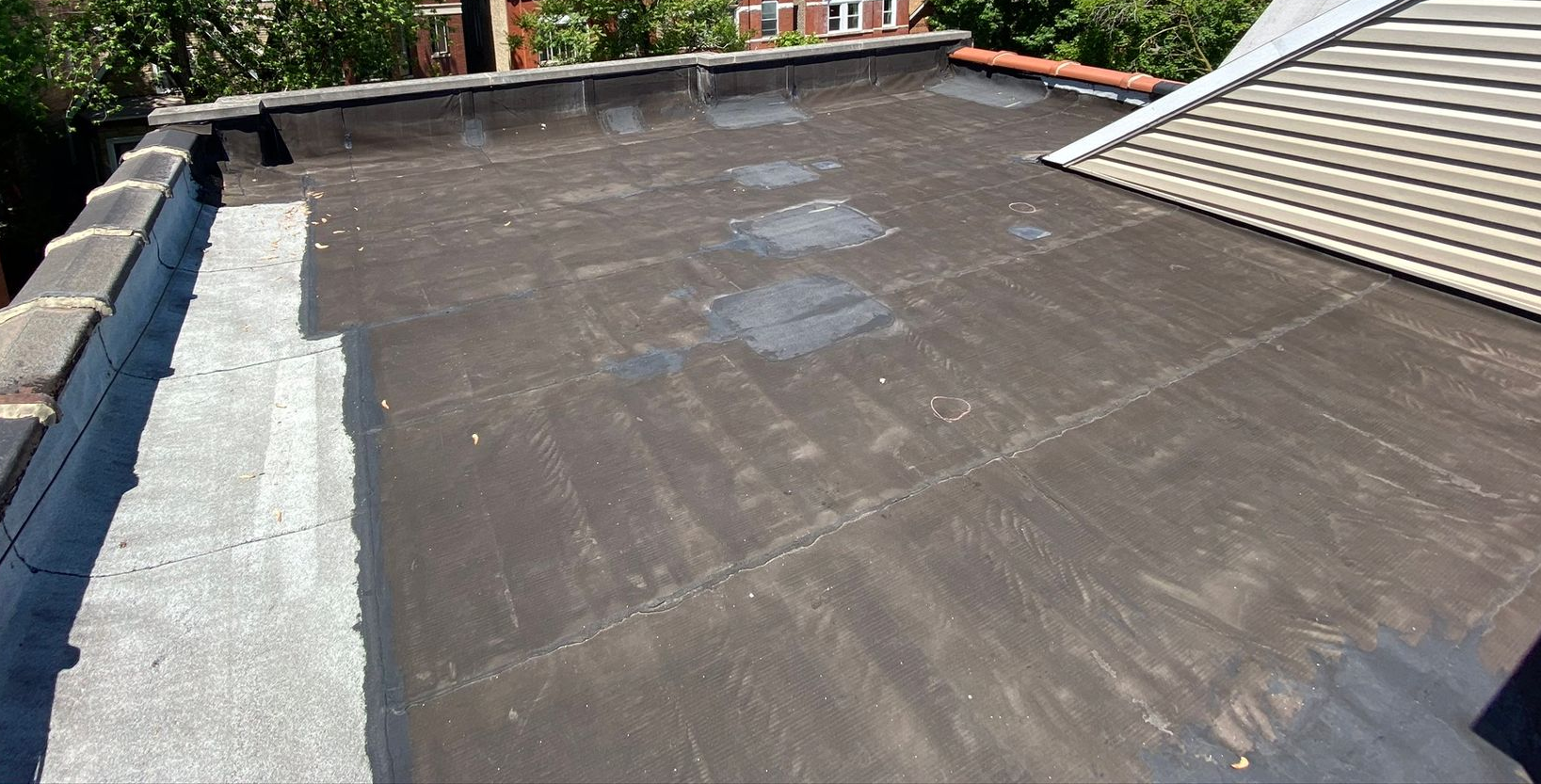 Installed black waterproofing on rooftop floor and parapet walls