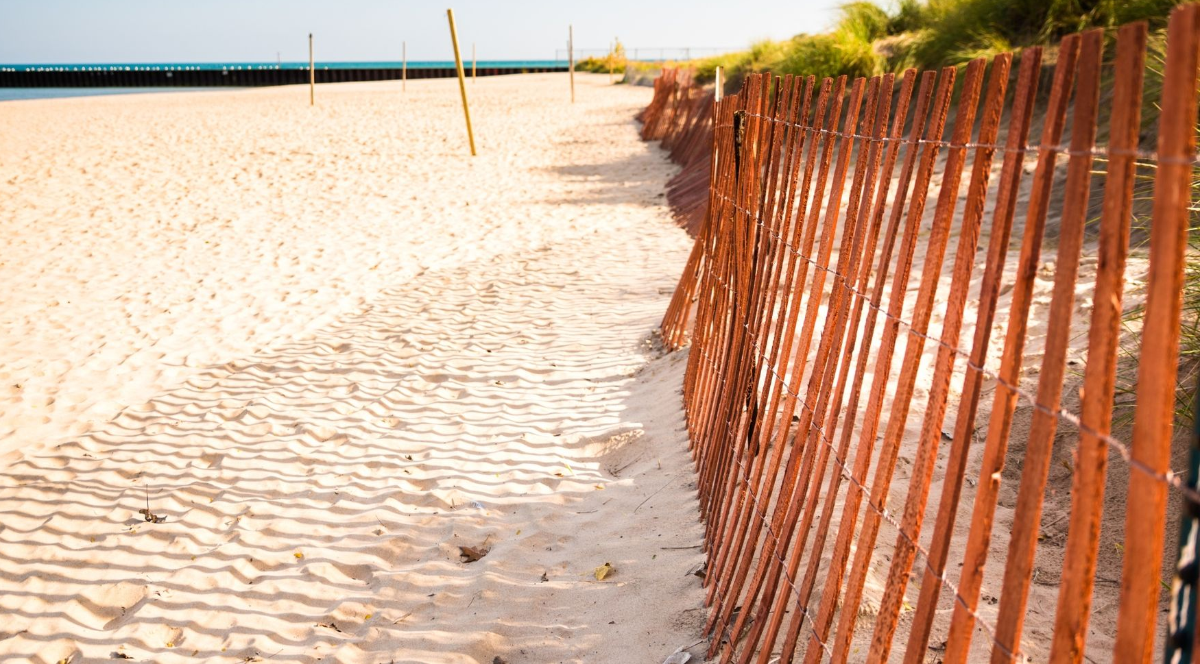 Orange fence along a sandy beach