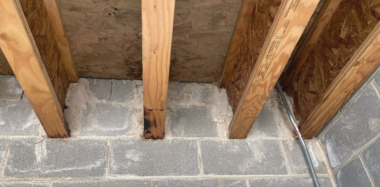 Wooden trusses connected to a concrete wall