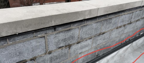Gray stone parapet wall along a paved walkway
