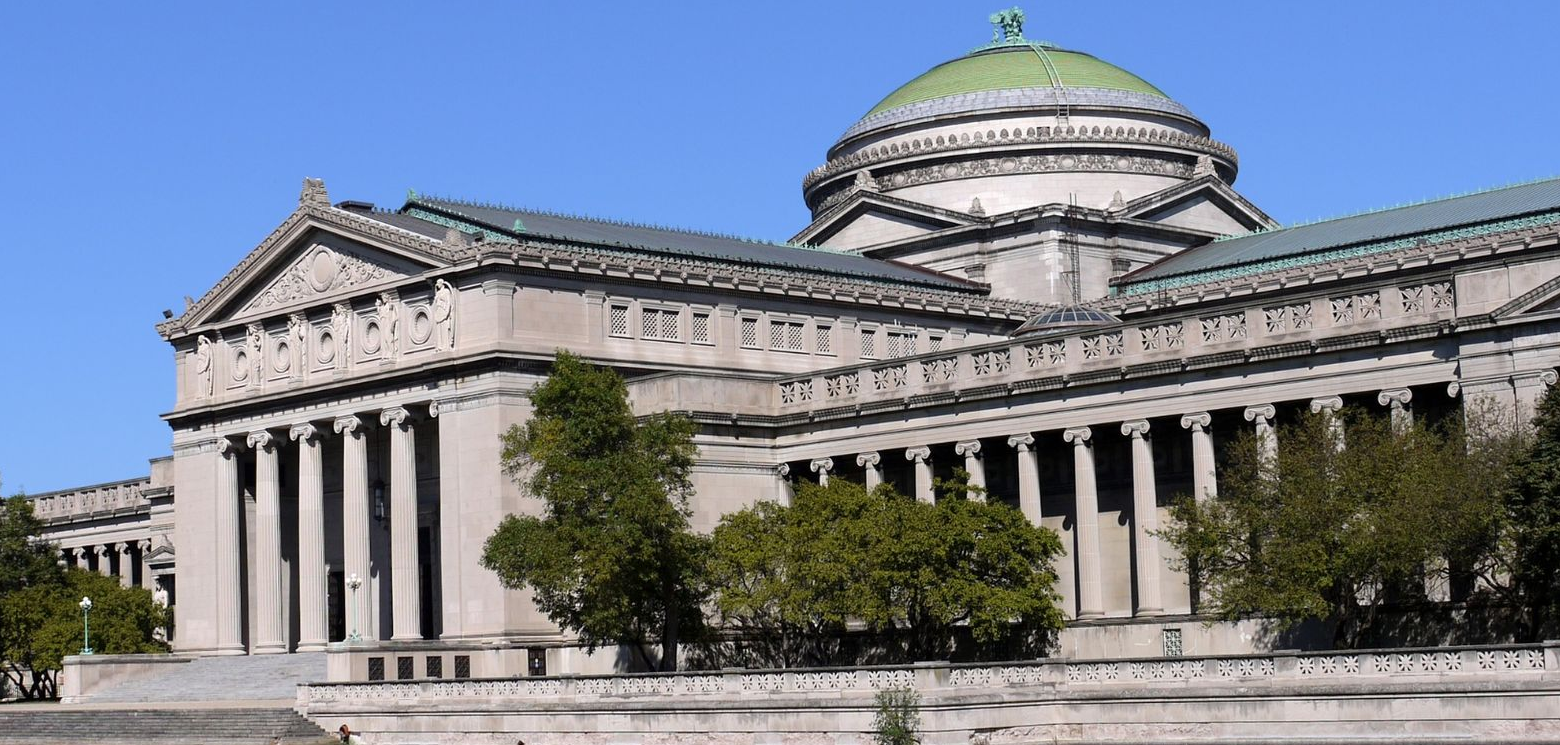 Large neoclassical building(Museum of Science) with columns and a green-domed roof