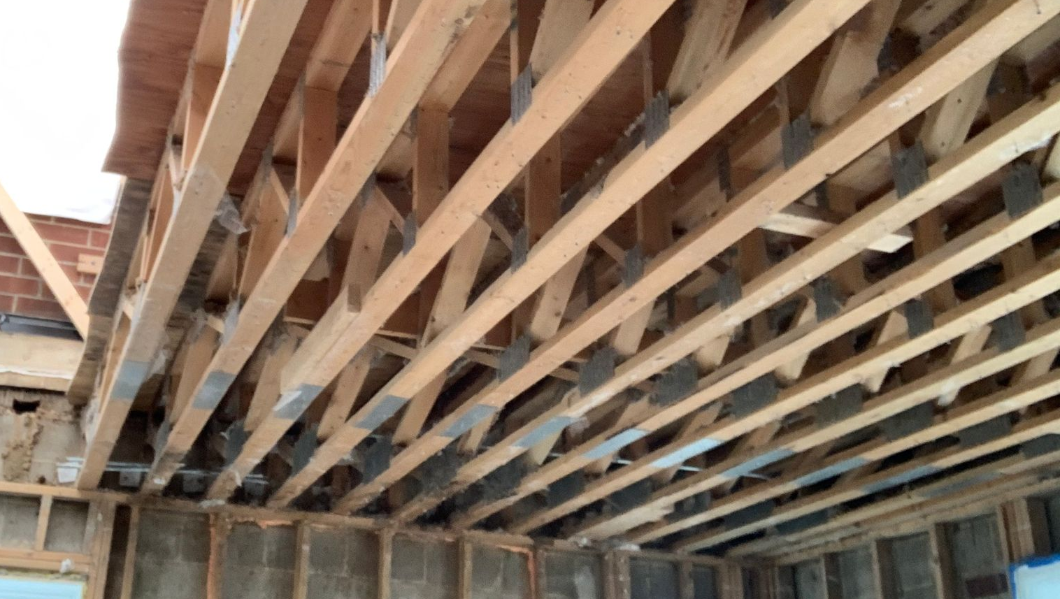 Wooden ceiling framing with exposed joists and beams in an unfinished interior space
