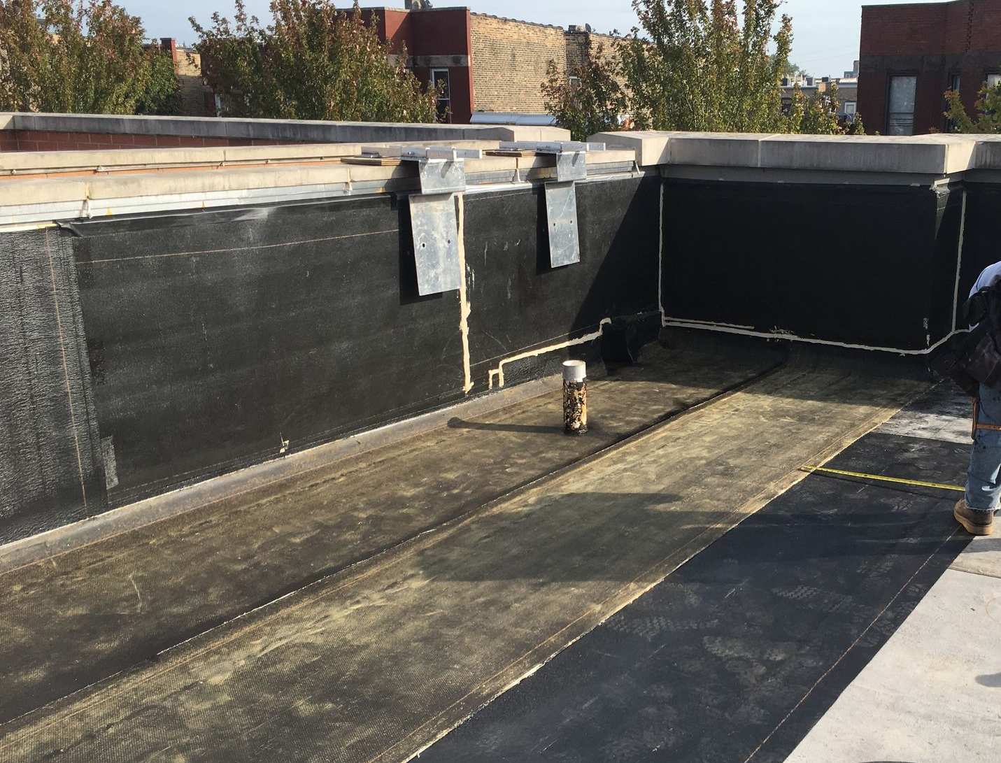 Installed black waterproofing on rooftop floor and parapet walls