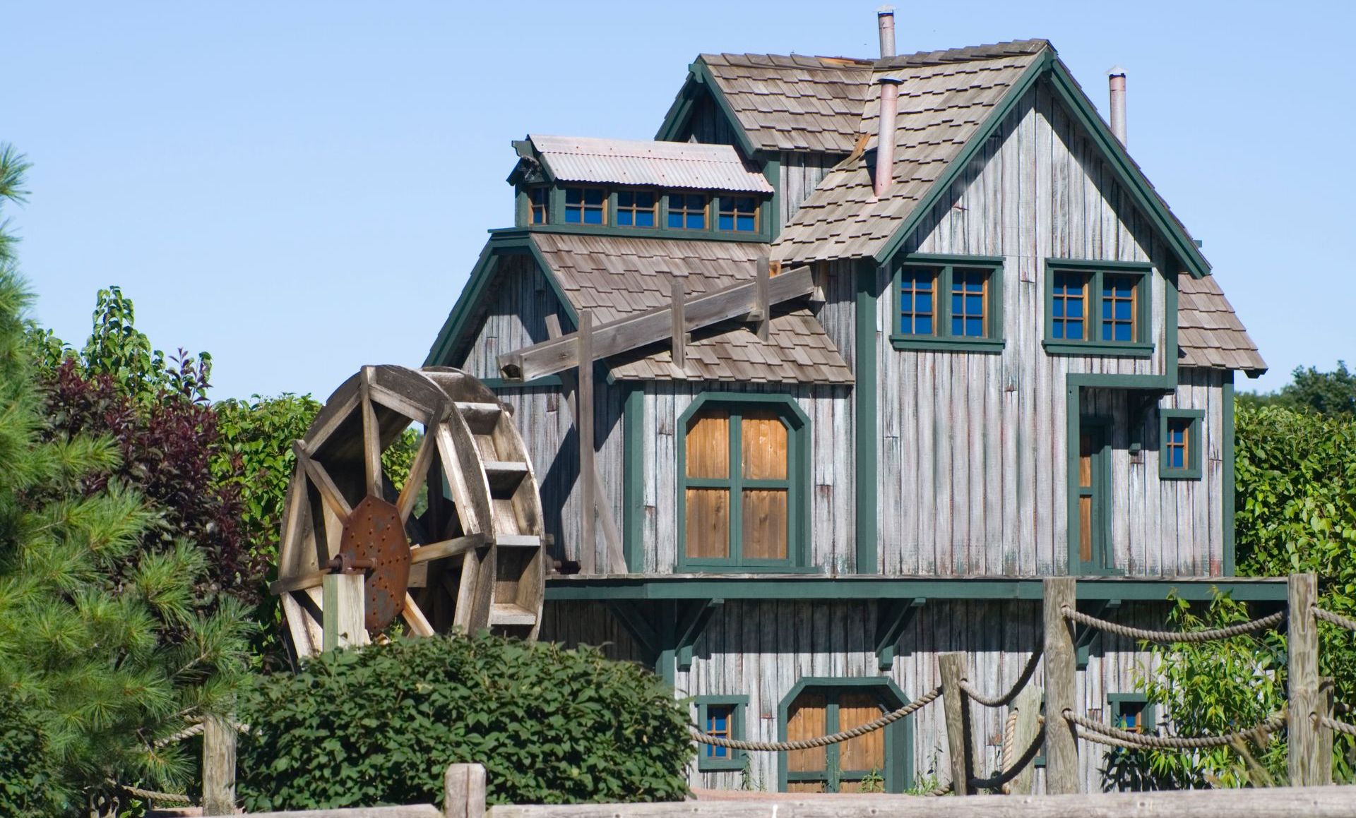 Rustic house with a large wooden water wheel beside it