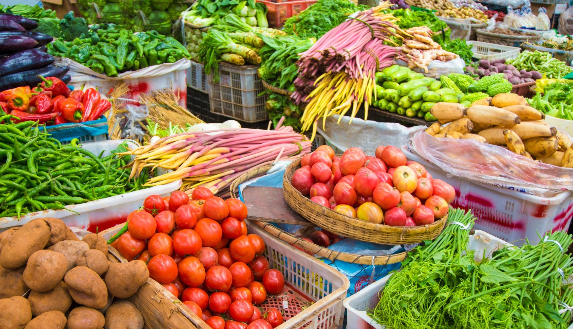 Colorful fresh vegetables and fruits displayed in market baskets and crates