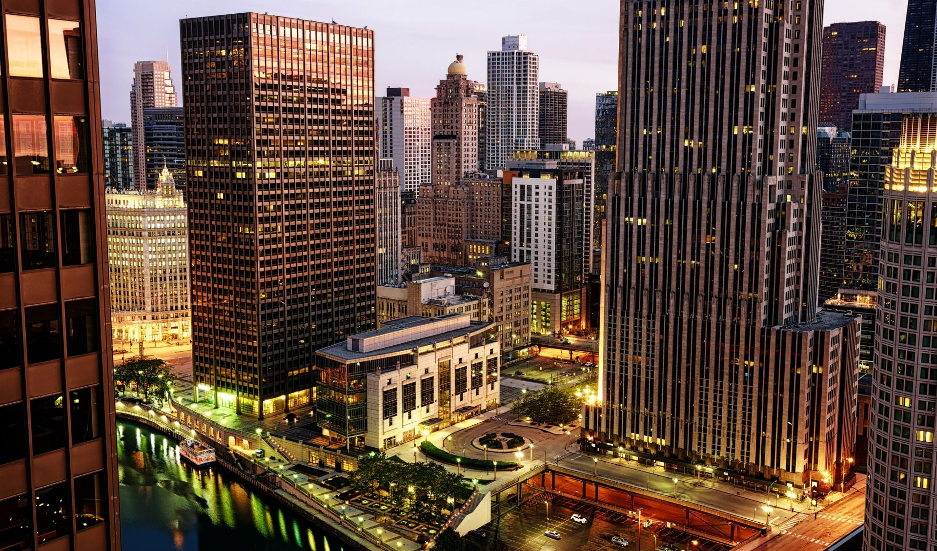 Chicago riverfront skyline at dusk with illuminated skyscrapers and city lights
