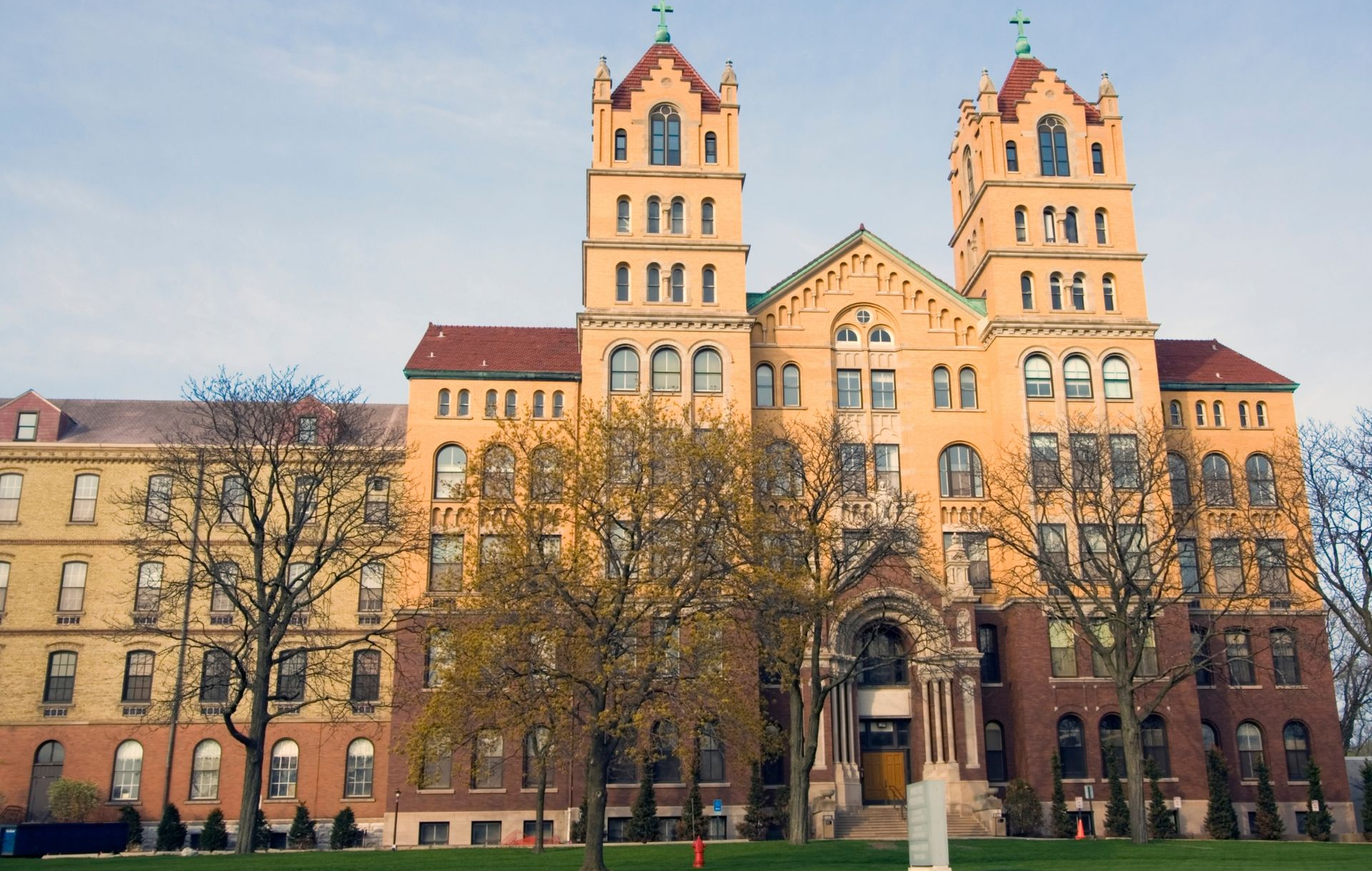 Historic tan stone building with twin towers and arched entrance