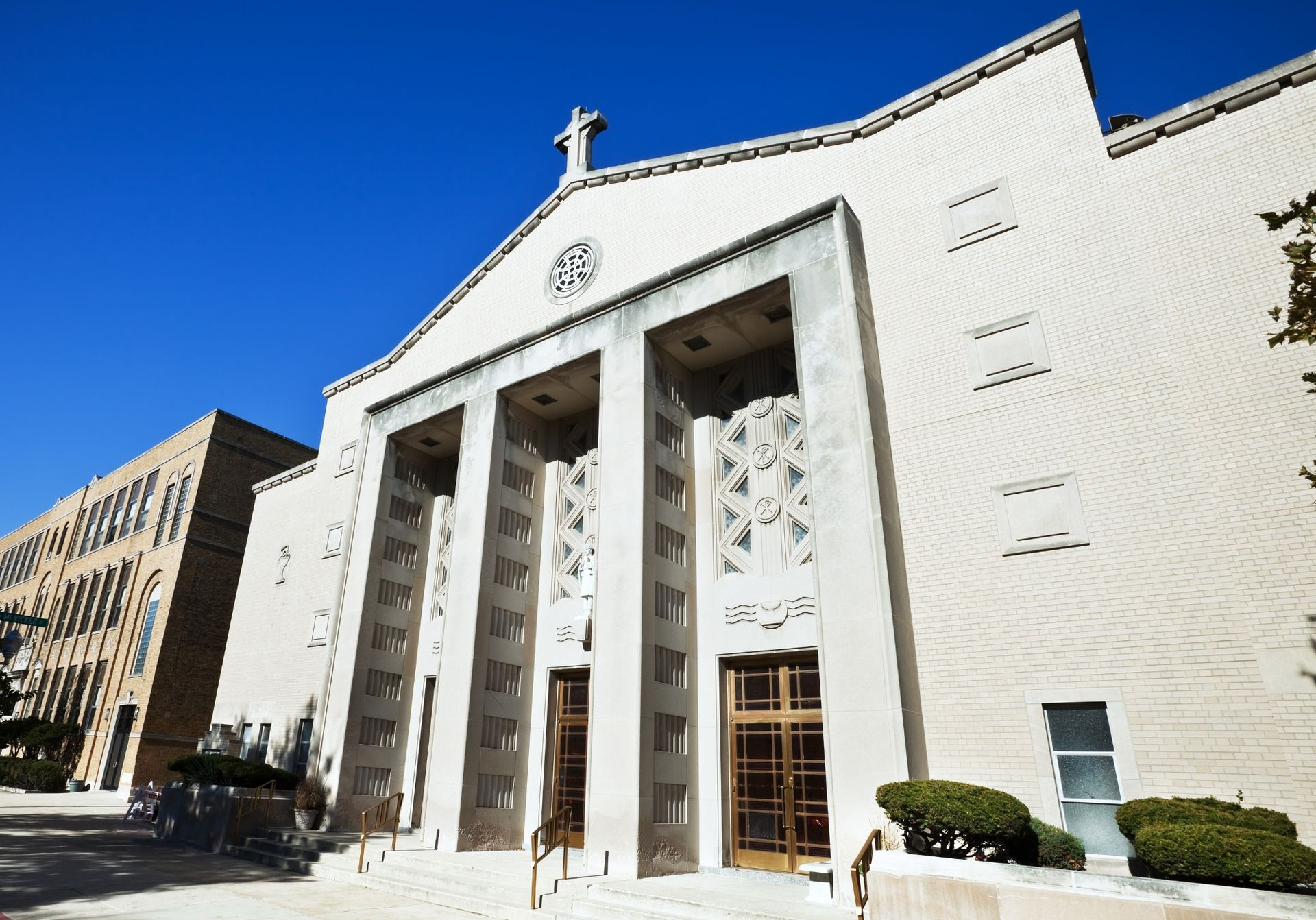 White civicchurch(Saint Tarcissus Church) with tall columns and arched entrance