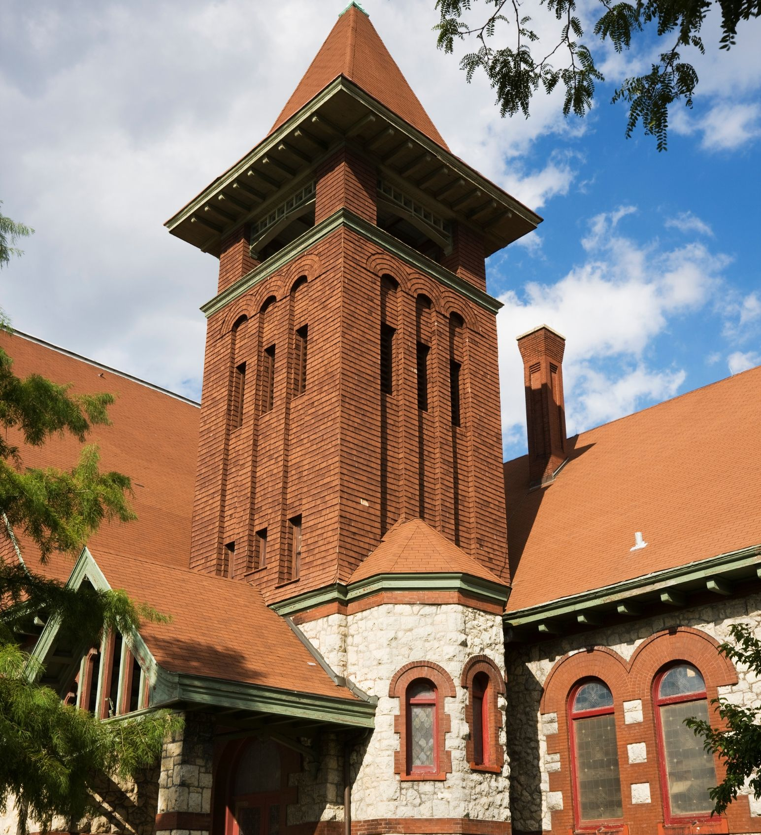 Historic red-brick church tower with a pointed roof