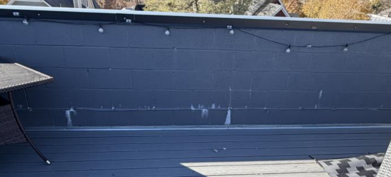 Dark gray parapet wall leaking efflorescence