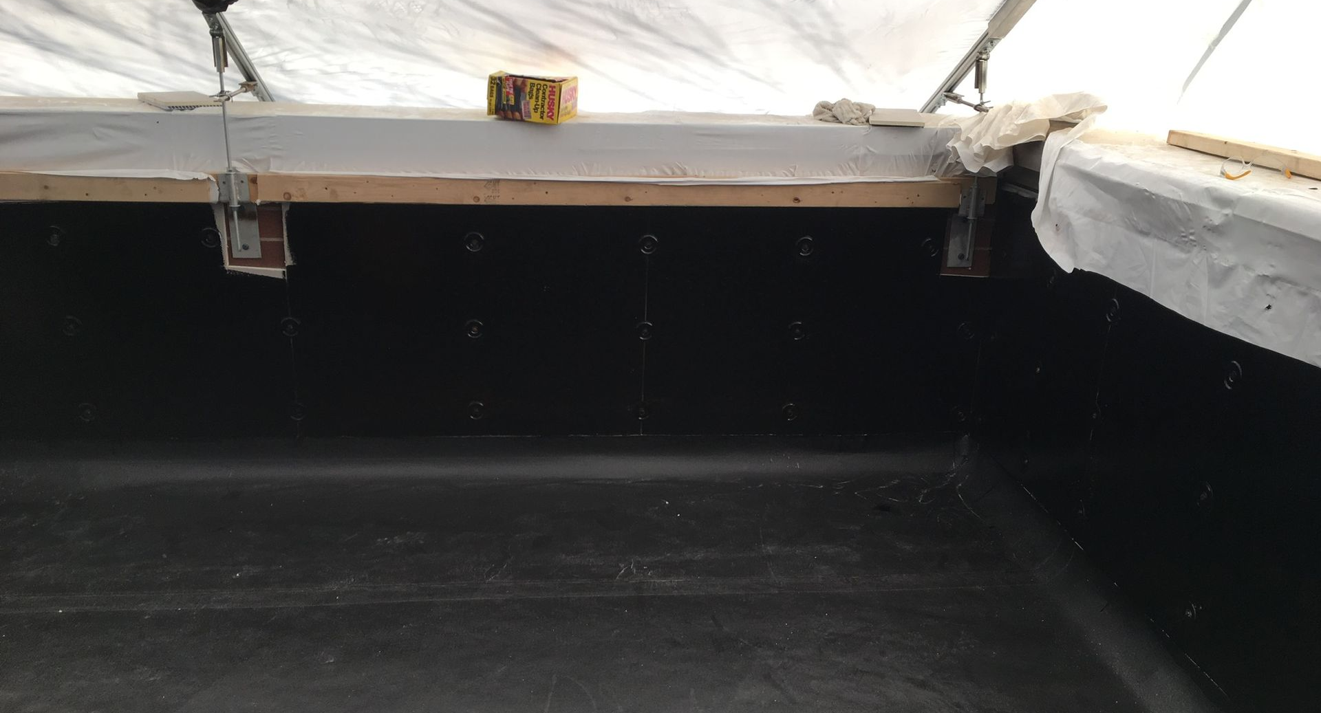 Installed black waterproofing on a rooftop floor and parapet wall