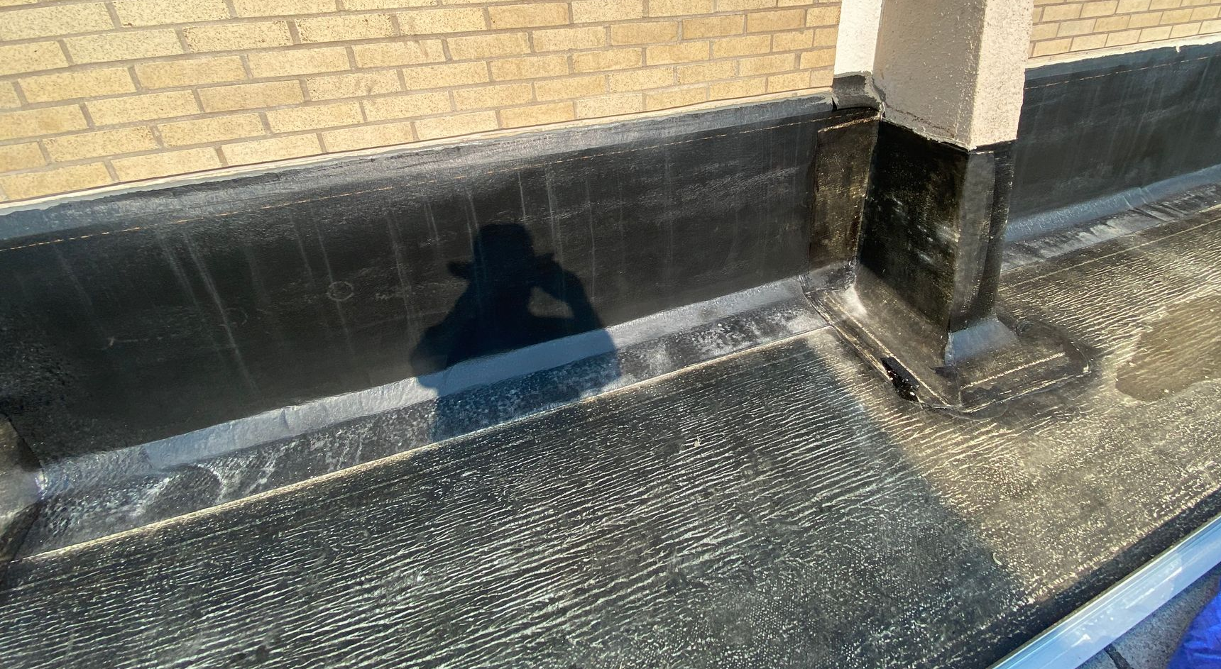 Brick building wall with black waterproofing installed